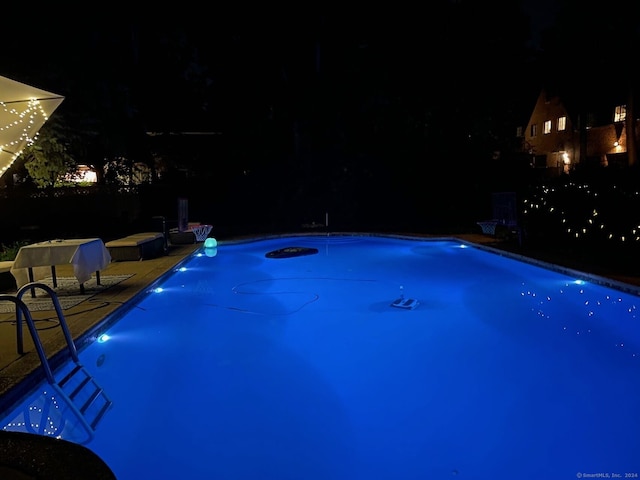 view of pool at twilight