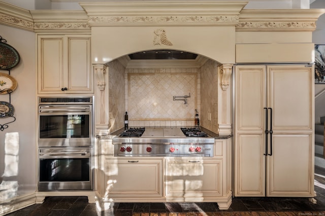 kitchen with cream cabinetry, crown molding, stainless steel appliances, and tasteful backsplash