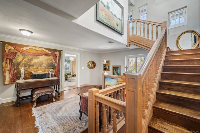 stairway with crown molding and wood-type flooring