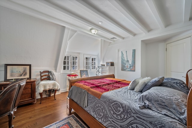 bedroom with hardwood / wood-style flooring and beamed ceiling