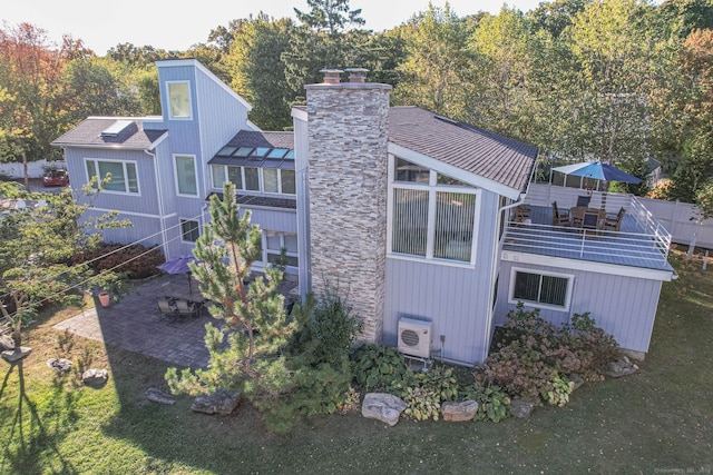 exterior space featuring a wooden deck, a patio area, and a lawn