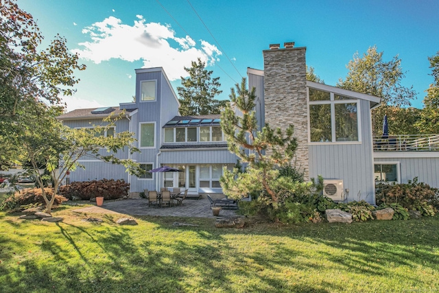 rear view of property with ac unit, a yard, and a patio