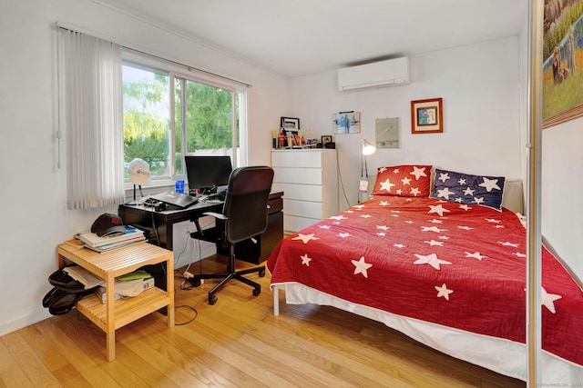 bedroom featuring a wall mounted air conditioner and hardwood / wood-style flooring