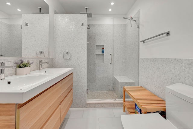 bathroom with an enclosed shower, toilet, tile walls, vanity, and tile patterned flooring