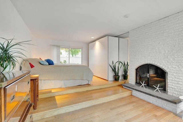 bedroom featuring hardwood / wood-style flooring and a fireplace