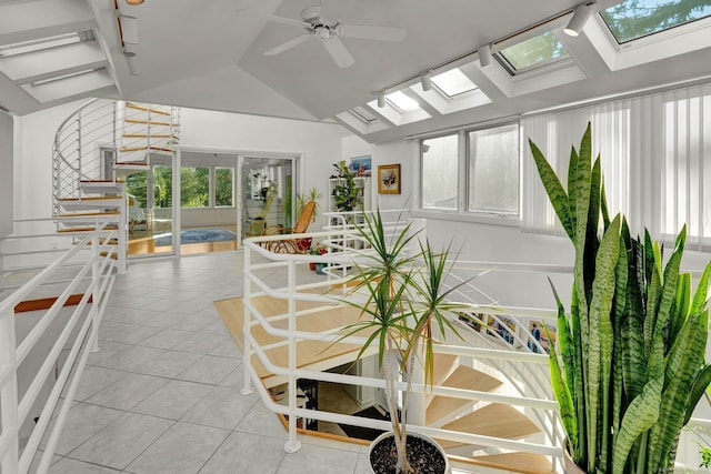 sunroom / solarium featuring ceiling fan, track lighting, and lofted ceiling