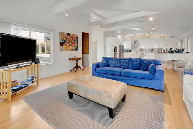 living room featuring lofted ceiling with beams and light wood-type flooring