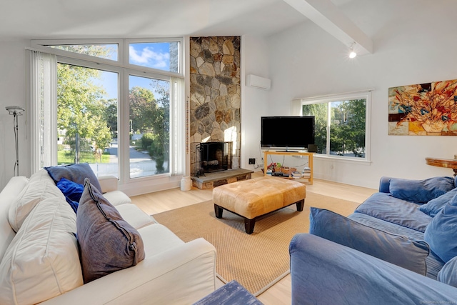 living room with light hardwood / wood-style floors, vaulted ceiling with beams, and a wealth of natural light