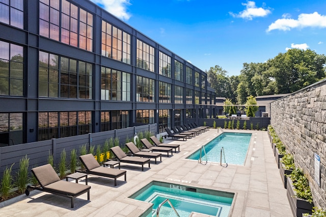 view of pool with a hot tub and a patio area