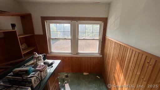 misc room featuring a wainscoted wall and wood walls