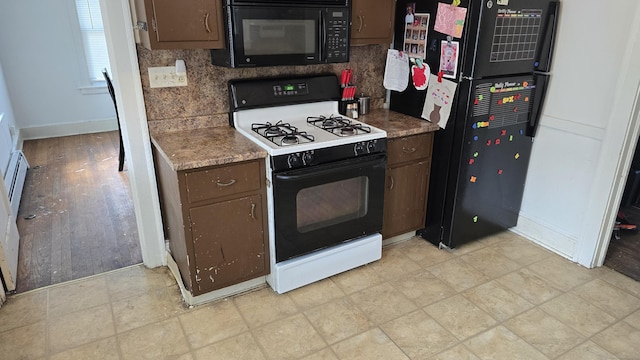 kitchen featuring baseboards, black appliances, and dark brown cabinets