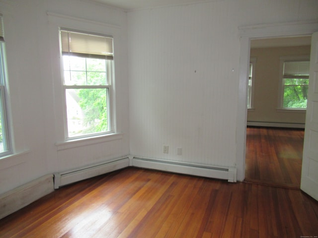 spare room with dark hardwood / wood-style floors and a baseboard radiator