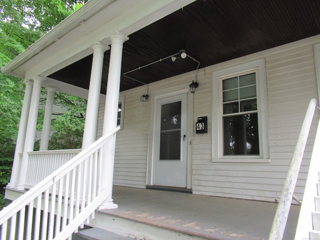 view of exterior entry featuring covered porch