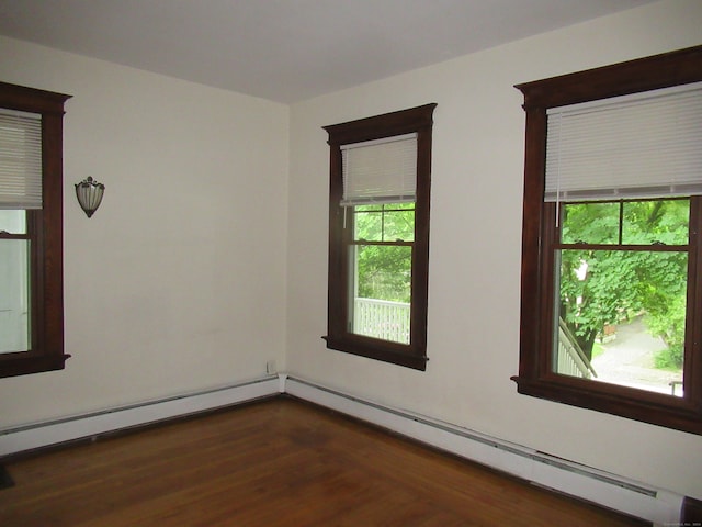 unfurnished room featuring a baseboard radiator and dark hardwood / wood-style flooring