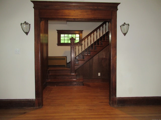 hall with radiator heating unit and dark hardwood / wood-style flooring