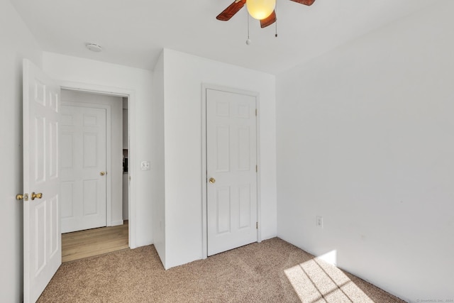 unfurnished bedroom featuring light carpet and ceiling fan