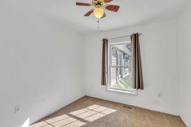 carpeted spare room with ceiling fan