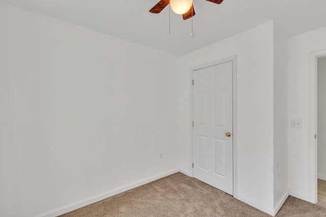 empty room featuring ceiling fan and light carpet