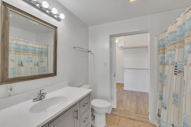 bathroom with tile patterned floors, vanity, curtained shower, and toilet