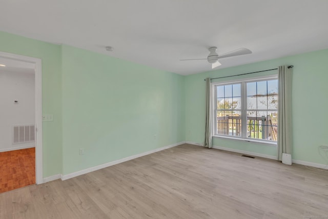 empty room with ceiling fan and light hardwood / wood-style flooring