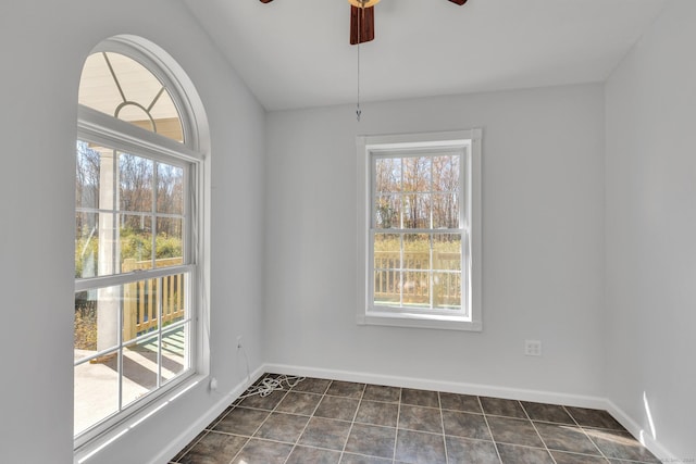 unfurnished room featuring ceiling fan and dark tile patterned floors