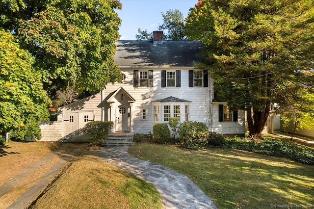 colonial house featuring a front lawn