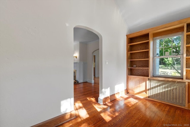 unfurnished room with lofted ceiling and wood-type flooring