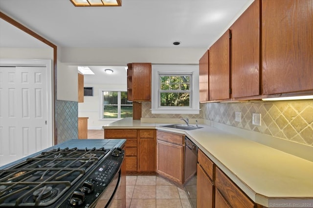 kitchen featuring sink, tasteful backsplash, black appliances, and light tile patterned flooring