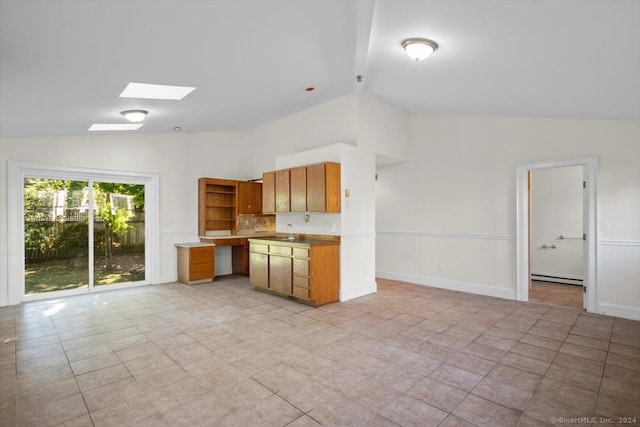 kitchen with vaulted ceiling with skylight, a baseboard heating unit, and light tile patterned floors