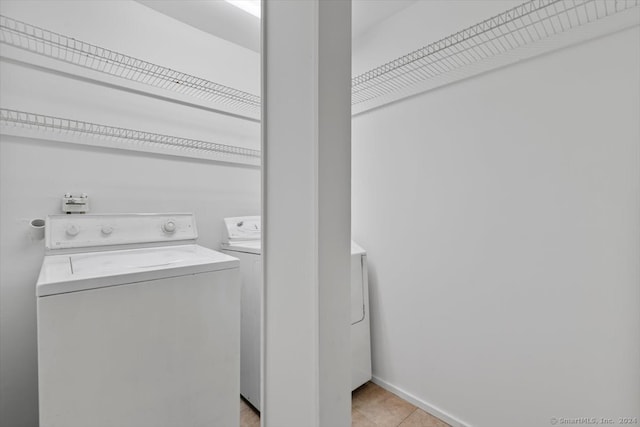 laundry area featuring washing machine and dryer and light tile patterned floors