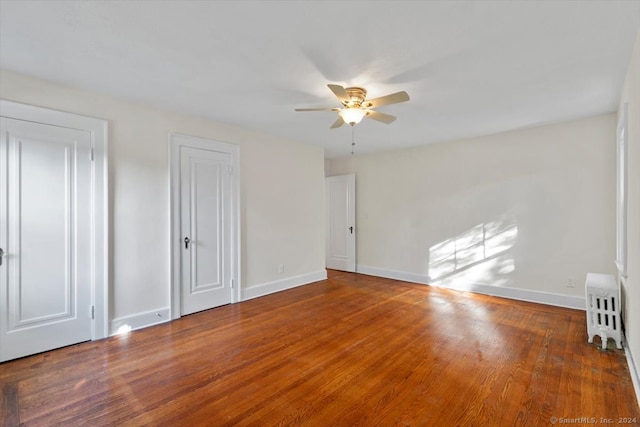 empty room with ceiling fan and hardwood / wood-style floors