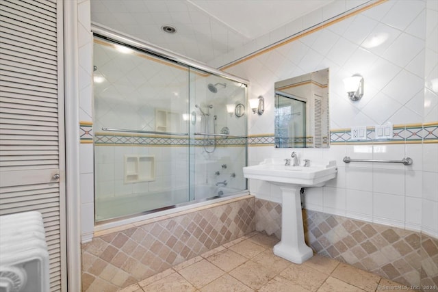 bathroom with radiator, enclosed tub / shower combo, tile walls, and tile patterned flooring