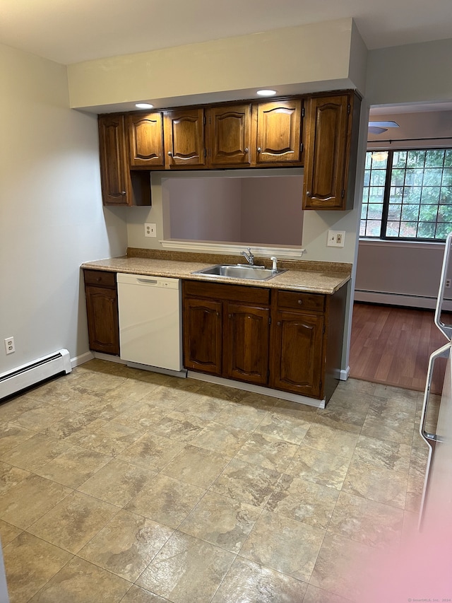 kitchen featuring white dishwasher, light wood-type flooring, sink, and a baseboard heating unit