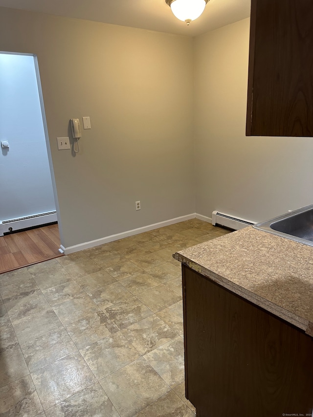 spare room featuring light wood-type flooring and a baseboard heating unit