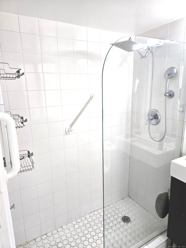 bathroom featuring a tile shower and vanity