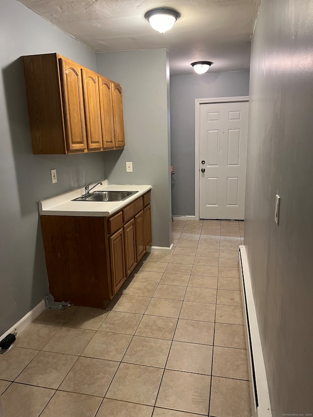 kitchen featuring sink, light tile patterned floors, and a baseboard radiator