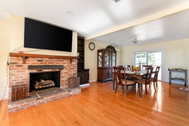 dining room with hardwood / wood-style floors and a fireplace