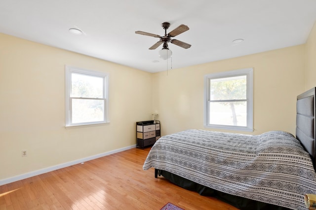 bedroom featuring light hardwood / wood-style flooring, multiple windows, and ceiling fan