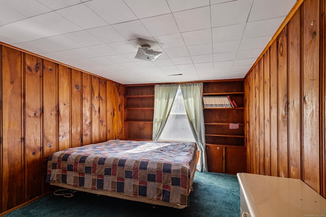 bedroom featuring dark carpet and wood walls