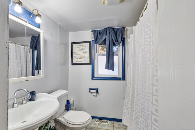 bathroom featuring toilet, walk in shower, and sink