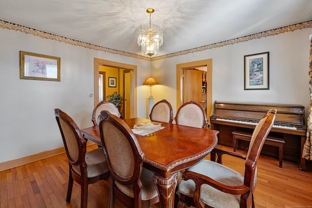 dining area with a notable chandelier and light hardwood / wood-style floors