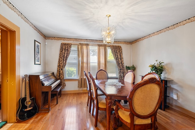 dining room with light hardwood / wood-style flooring and a notable chandelier