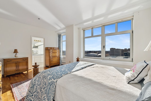 bedroom with hardwood / wood-style floors and ensuite bathroom