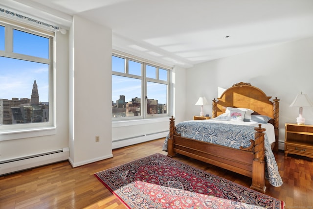 bedroom featuring hardwood / wood-style floors and a baseboard radiator