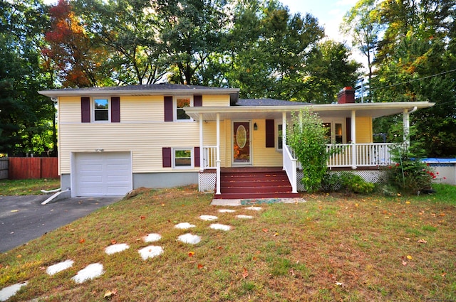 view of front of home with a front yard, a porch, and a garage