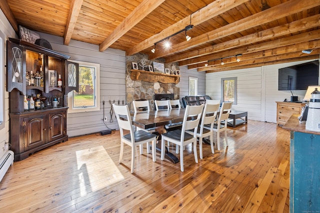 dining area with beam ceiling, track lighting, light hardwood / wood-style floors, and wood ceiling