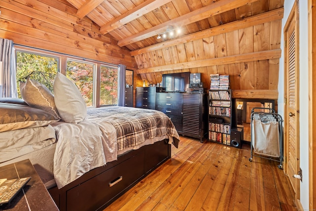 bedroom featuring wood-type flooring, lofted ceiling with beams, wooden walls, and wood ceiling