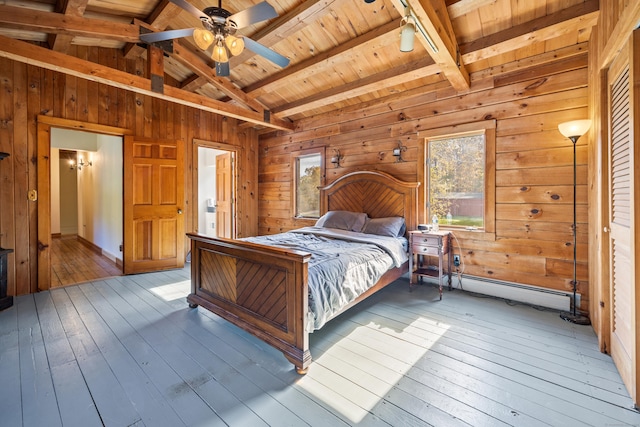 bedroom with wood walls, ceiling fan, and light hardwood / wood-style floors