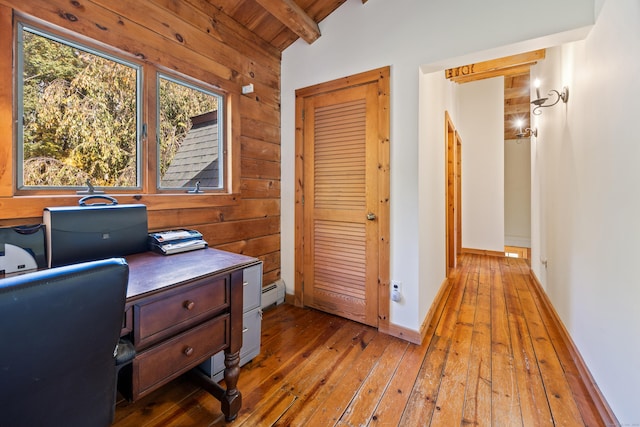 office space with hardwood / wood-style flooring, lofted ceiling with beams, baseboard heating, and wooden walls