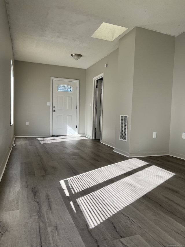 entryway featuring dark hardwood / wood-style floors, a textured ceiling, and a skylight